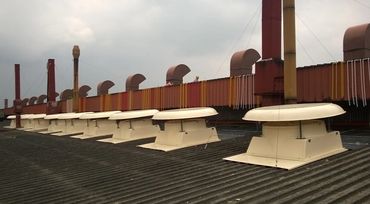 Industrial exhaust ducting installed along the edge of a factory rooftop